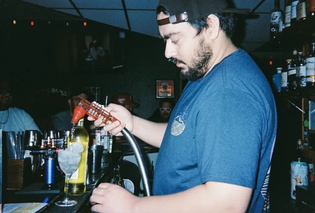 A bartender prepares a drink behind the Easy Tiger bar.